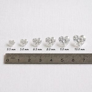 Heart cut diamond scale showing precise millimeter sizes from 3.5mm to 10.0mm lined up against a metal metric ruler.