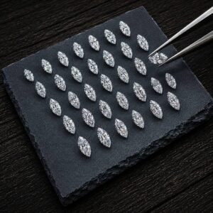 Loose marquise diamonds in a precise grid layout on slate with jeweler tweezers.