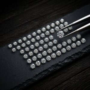 Premium round brilliant loose lab grown diamonds arranged by size on a black slate display with tweezers holding a larger diamond.